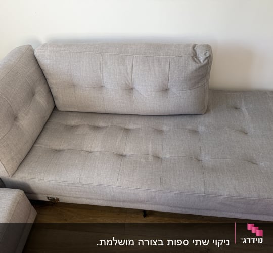 ספה אפורה על רצפת עץ בחדר